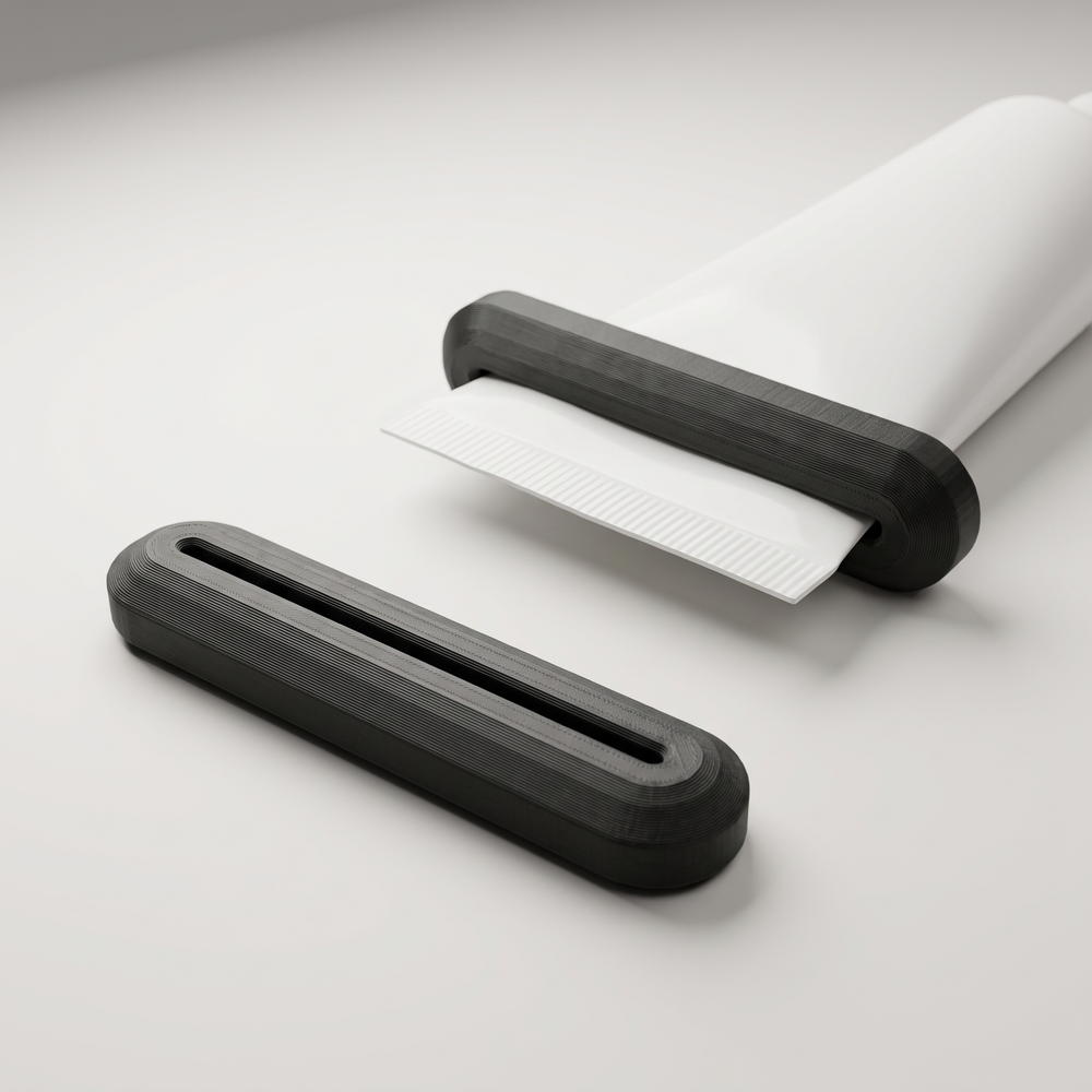 AI-assisted studio illustration of the two-pack black PETG tube squeezers, with one shown on an example unbranded tube. Tube and contents are not included.